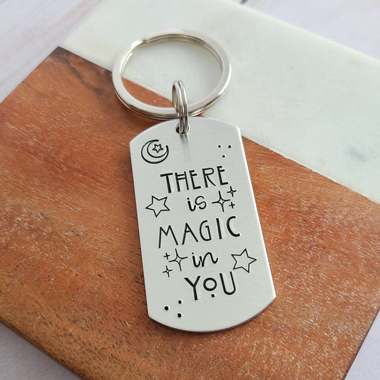 Silver keychain that reads There is Magic in You with stars around it